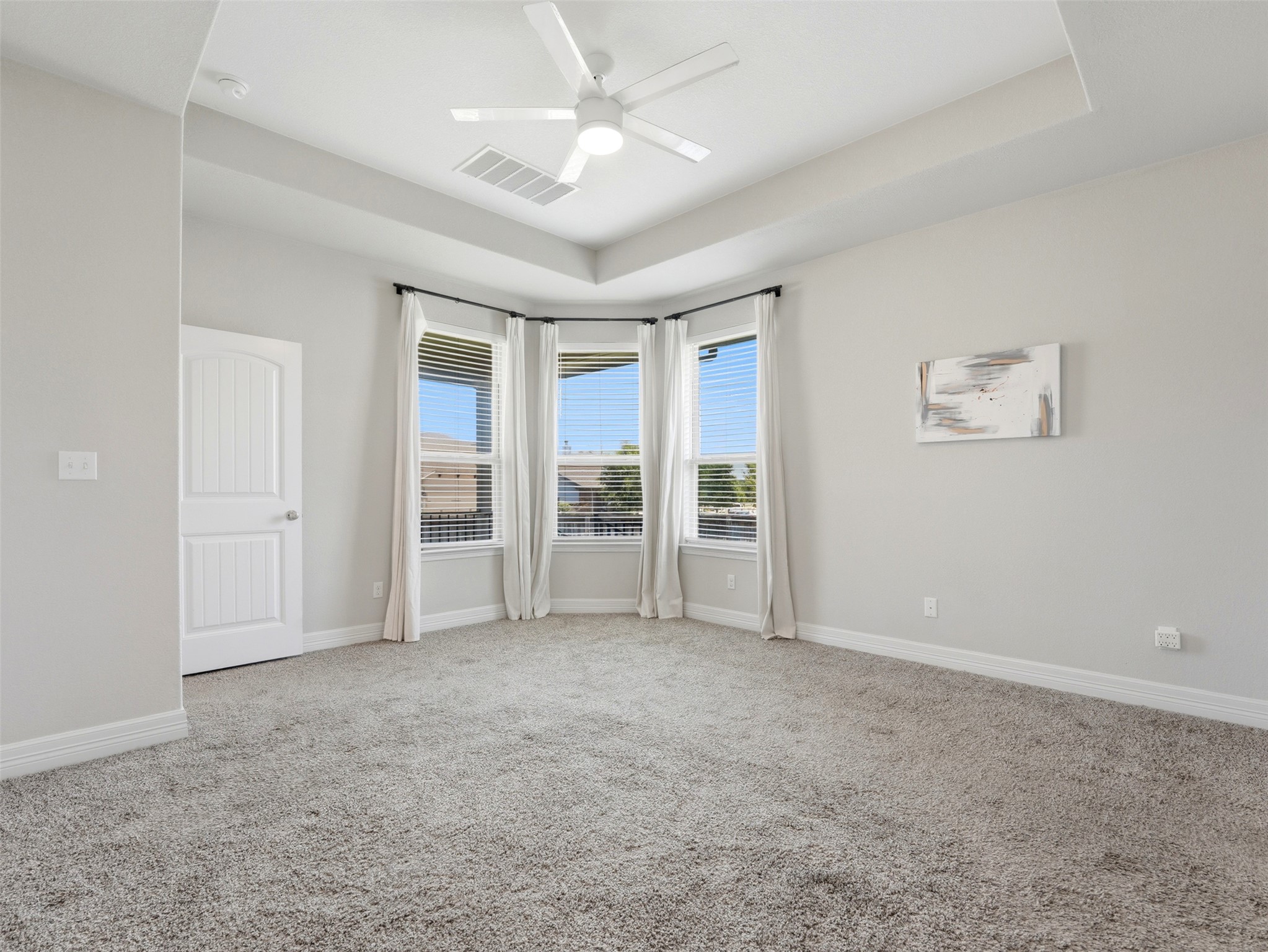 2132 Ringstaff Road Leander, TX 78641 - Photo 20 of 39 A quiet bedroom retreat awaits with plush carpeting, a tray ceiling, and a bright bay window.
