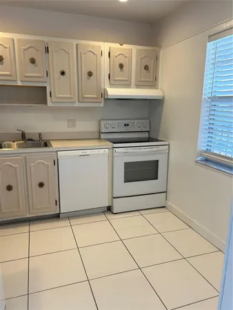 a kitchen with white cabinets and white appliances
