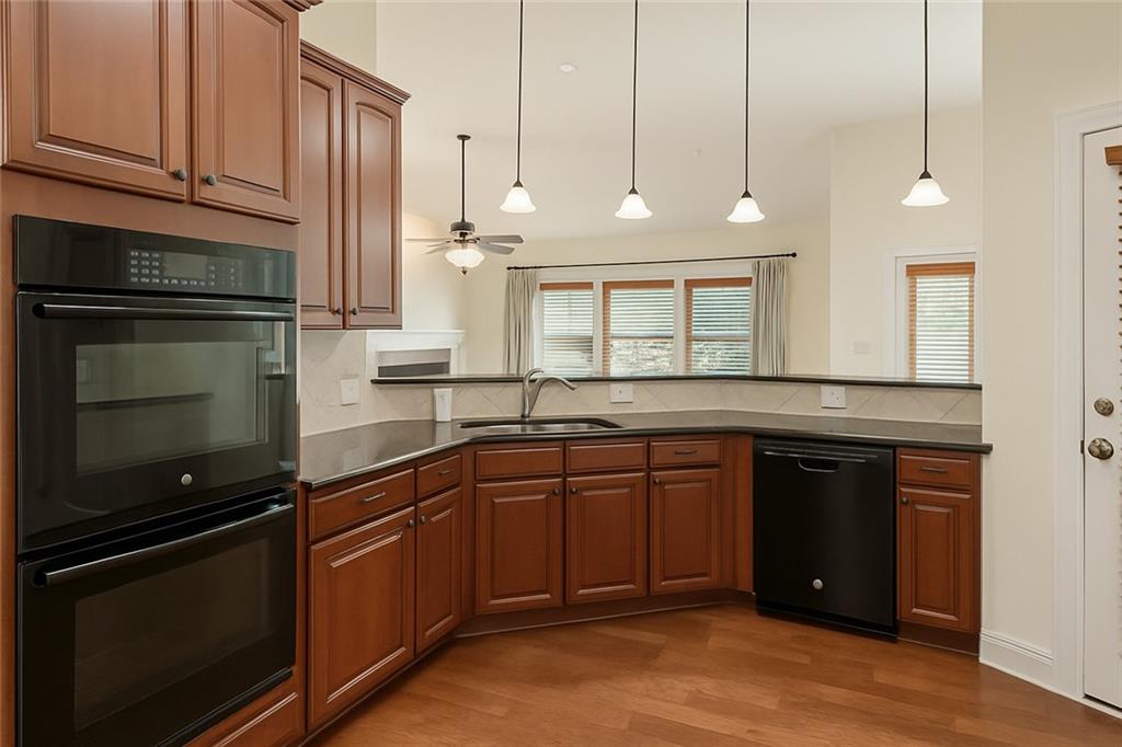 2231 Cain Commons Drive Dacula, GA 30019 - Photo 9 of 20 a kitchen with stainless steel appliances granite countertop a stove a sink and a microwave