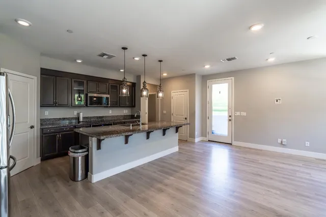 an open kitchen with white cabinets and stainless steel appliances