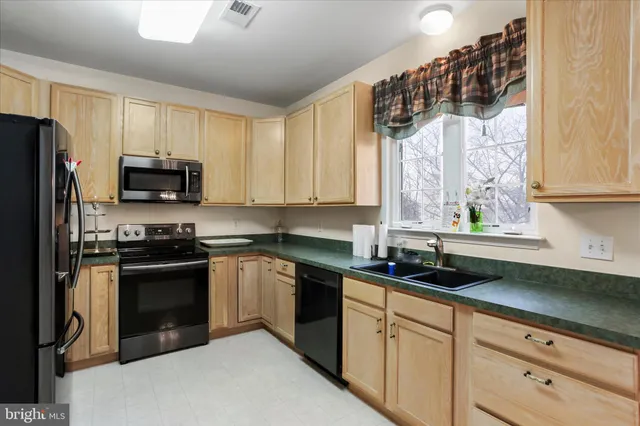 a kitchen with a sink a stove and cabinets