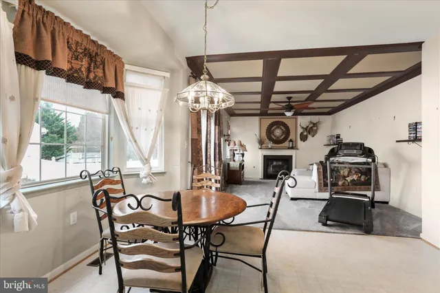 a view of a dining room with furniture a chandelier and a large window
