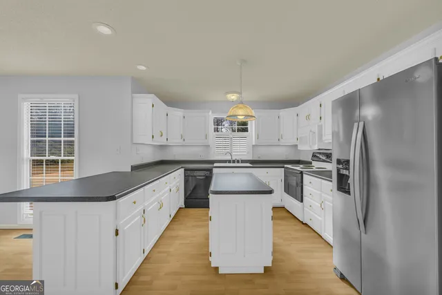 a kitchen that has a sink a stove and a wooden floors