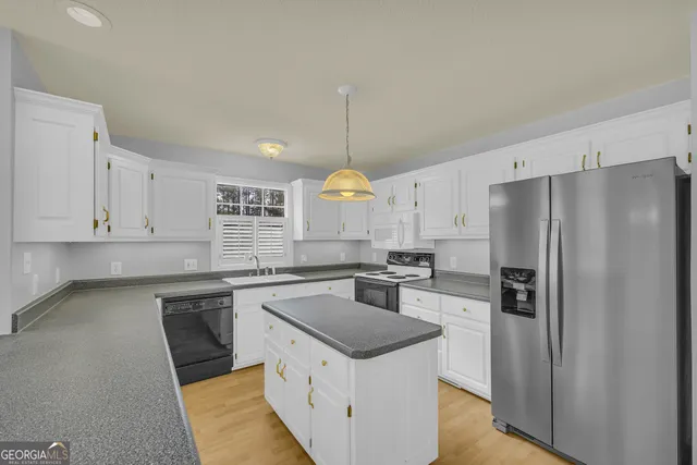 a kitchen with stainless steel appliances granite countertop a sink a stove and white cabinets
