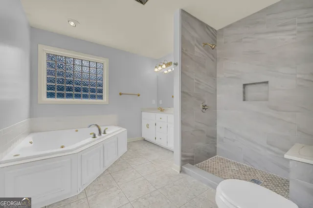 a bathroom with a tub a sink and mirror