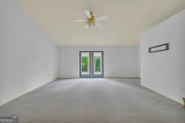 a view of a room with a ceiling fan and fireplace