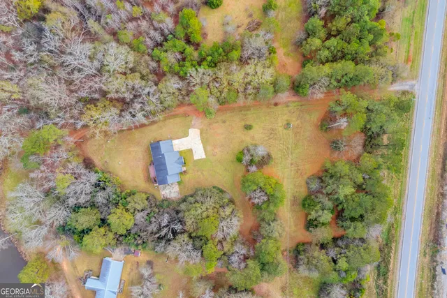 a view of a house with a yard and large tree