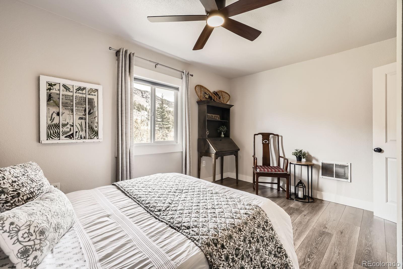 57920 US Highway 285, Unit 8 Bailey, CO 80421 - Photo 12 of 29 a bedroom with a bed bookshelf and a large window