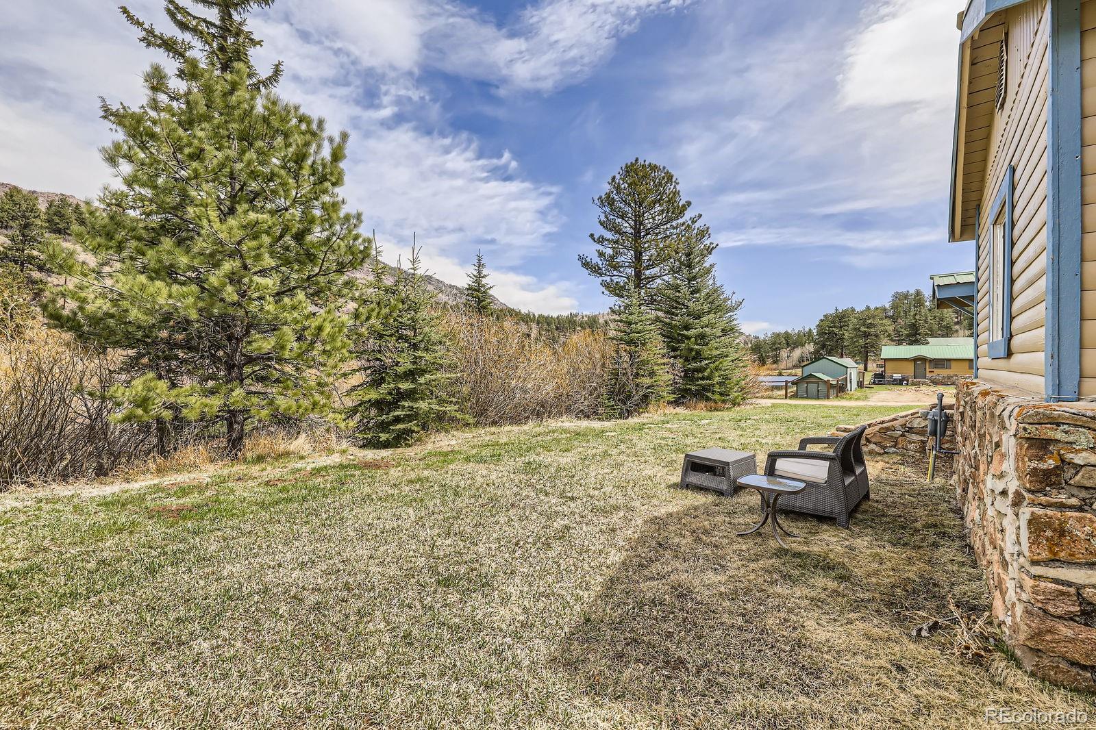 57920 US Highway 285, Unit 8 Bailey, CO 80421 - Photo 17 of 29 a wooden bench sitting in middle of a field