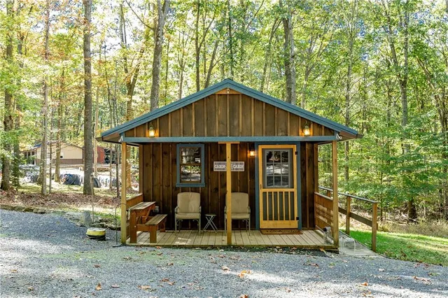 a small barn with a small yard and large trees