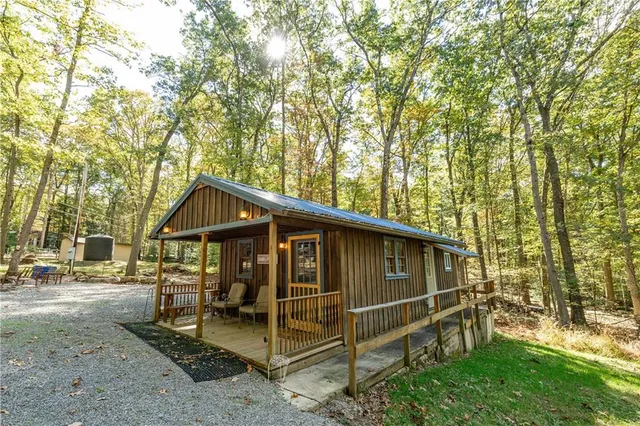 a view of a chair and table in the backyard with large trees