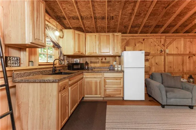 a kitchen with a refrigerator and white cabinets