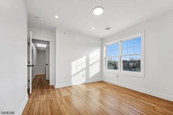 an empty room with wooden floor and a window