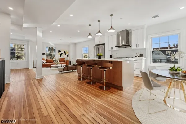 an open kitchen with kitchen island wooden floors and center island