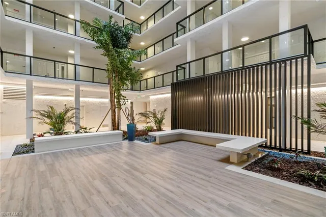 a view of an empty room with wooden floor and windows