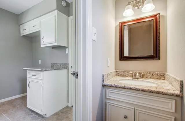 a view of staircase with lots of frames on wall and wooden floor