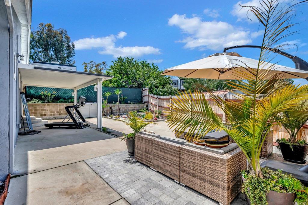 1601 Pepper Drive El Cajon, CA 92021 - Photo 30 of 31 a view of a patio with couches table and chairs under an umbrella with a fire pit