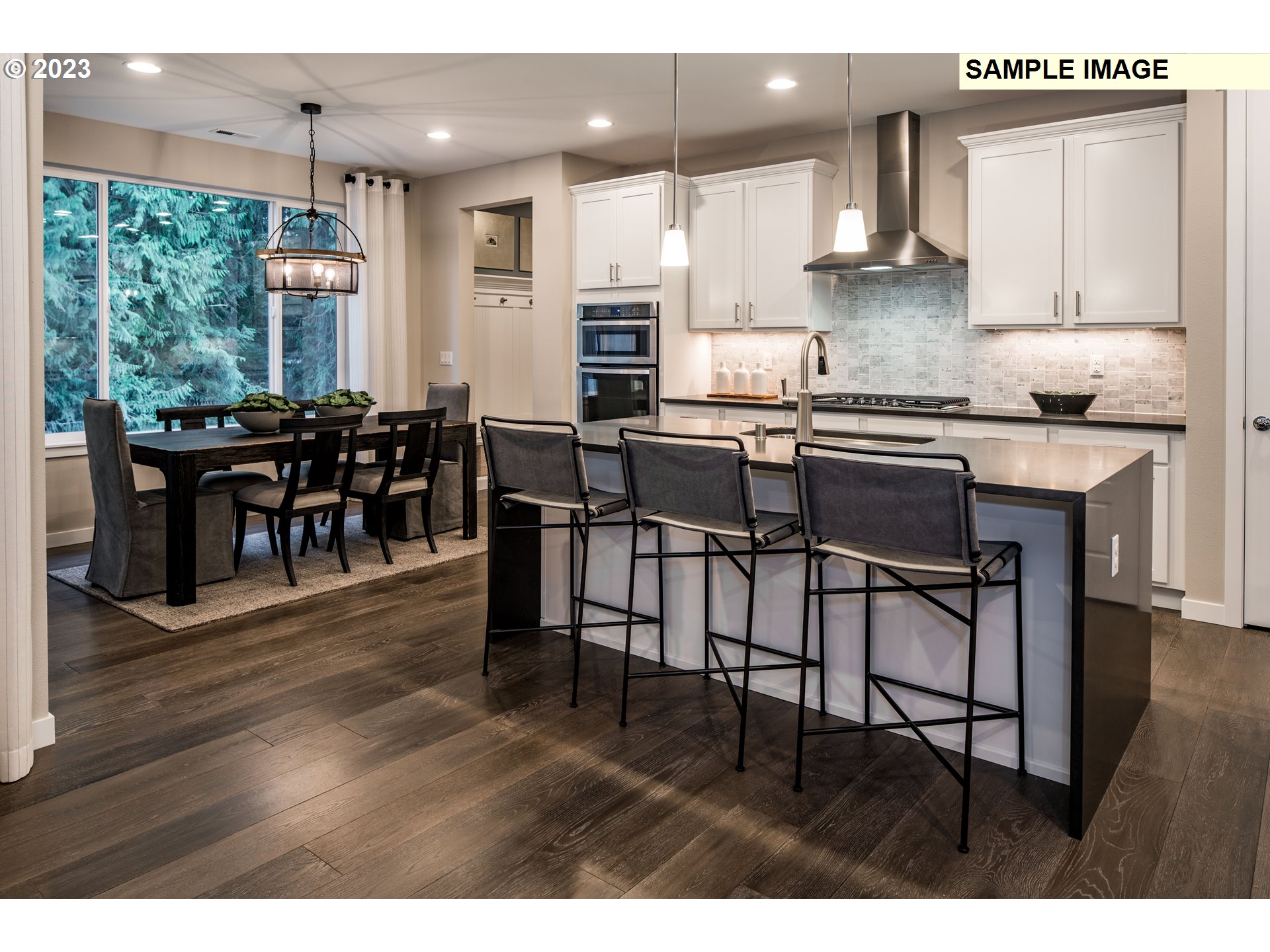 358 South 87th Avenue Ridgefield, WA 98642 - Photo 9 of 27 a kitchen with stainless steel appliances granite countertop a stove top oven a sink a dining table and chairs with wooden floor