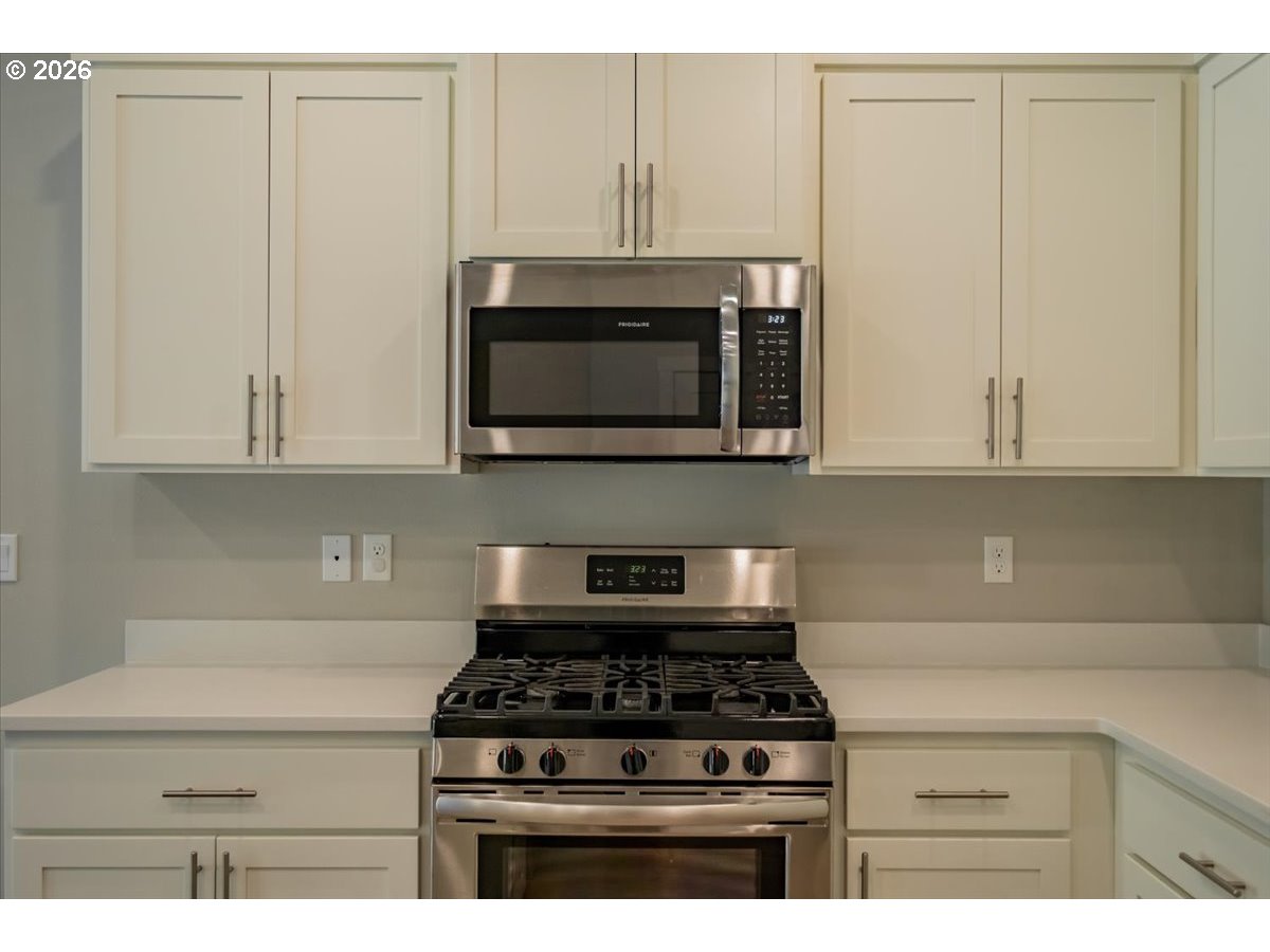 315 Cypress Street Mount Angel, OR 97362 - Photo 13 of 43 a kitchen with granite countertop white cabinets and stainless steel appliances