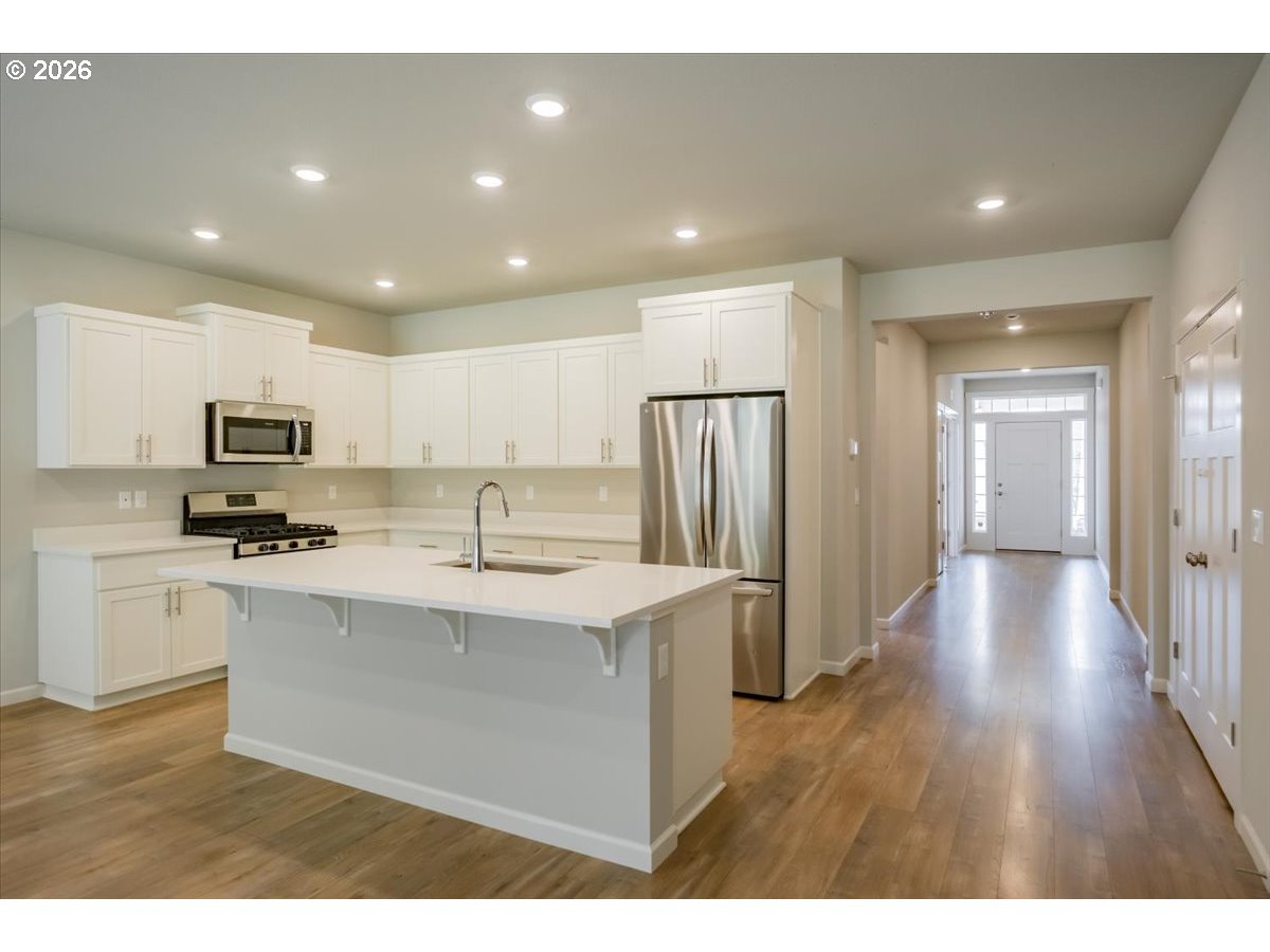 315 Cypress Street Mount Angel, OR 97362 - Photo 10 of 43 a kitchen with stainless steel appliances granite countertop a refrigerator a sink dishwasher a stove and white countertops with wooden floor