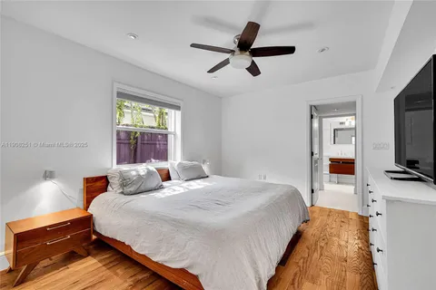 a bedroom with a bed and a flat tv screen on dresser