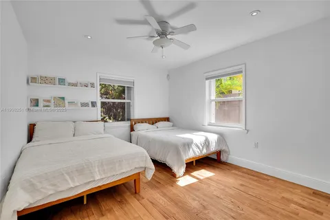 a bedroom with two beds and painting on the wall