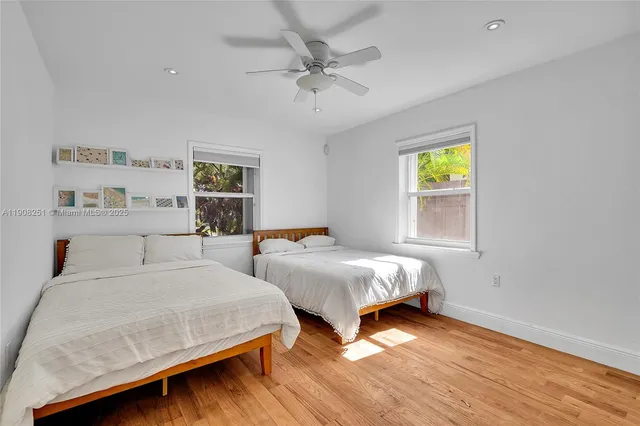 a bedroom with two beds and painting on the wall