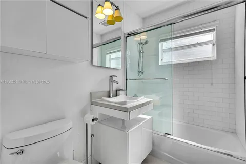 a bathroom with a sink toilet vanity and tub