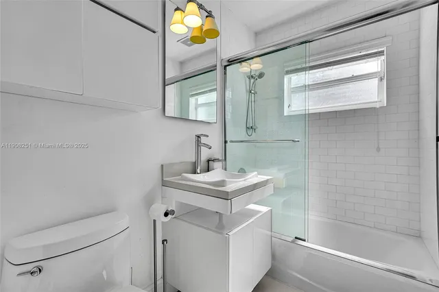 a bathroom with a sink toilet vanity and tub