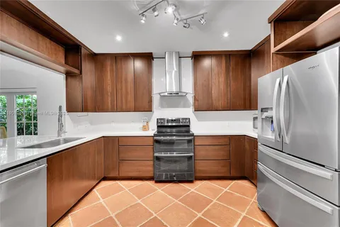 a kitchen with stainless steel appliances granite countertop a refrigerator and a sink