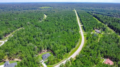 an aerial view of a house with a lush green forest