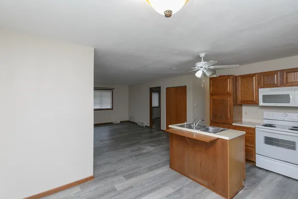 a kitchen with kitchen island stainless steel appliances a sink cabinets and wooden floor
