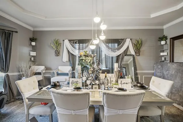 a view of a dining room with furniture and chandelier