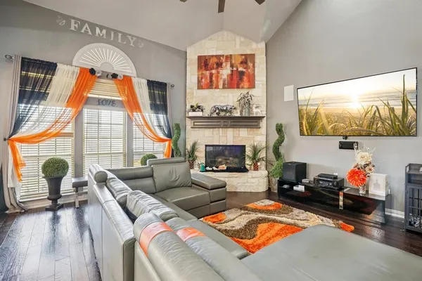 a living room with furniture a fireplace and a flat screen tv