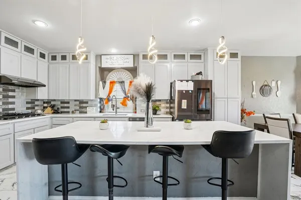 a kitchen with a dining table cabinets and chairs