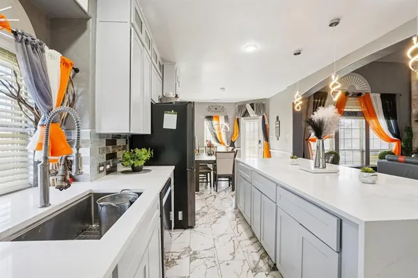 a kitchen with kitchen island granite countertop a sink a counter top space and stainless steel appliances