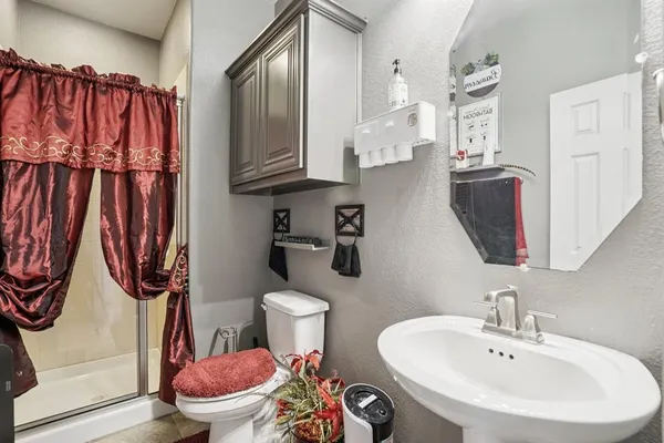 a bathroom with a sink a toilet and a shower curtain