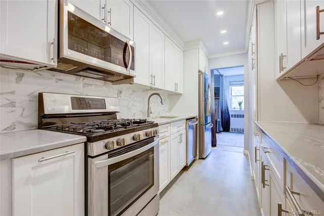 a kitchen with stainless steel appliances granite countertop a stove and a microwave