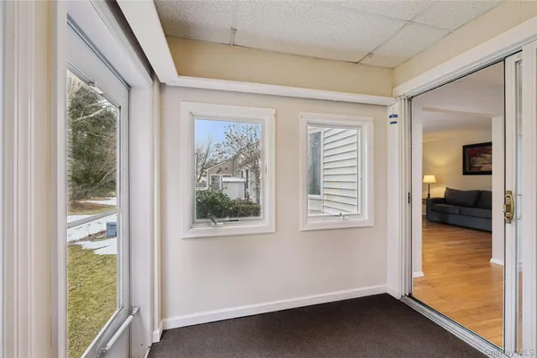 a view of hallway with a large window and wooden floor