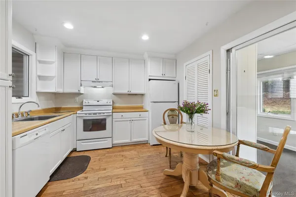 a kitchen with a white stove top oven and white cabinets