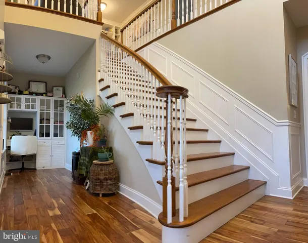 a open kitchen with stainless steel appliances granite countertop a refrigerator oven a stove a dining table and chairs with wooden floor