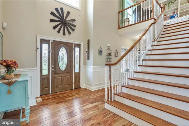 a kitchen with kitchen island granite countertop wooden floors white cabinets and stainless steel appliances