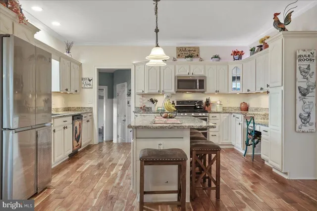 a bedroom with a bed a chair and potted plant on the dresser