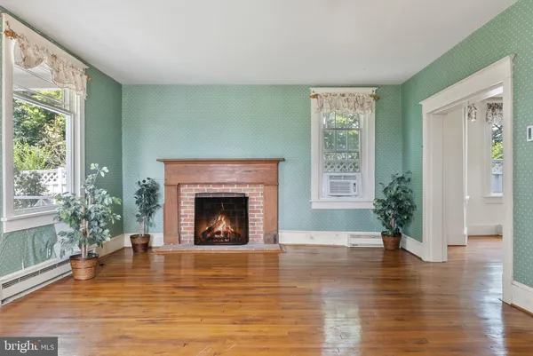 a view of an empty room with window and fire place