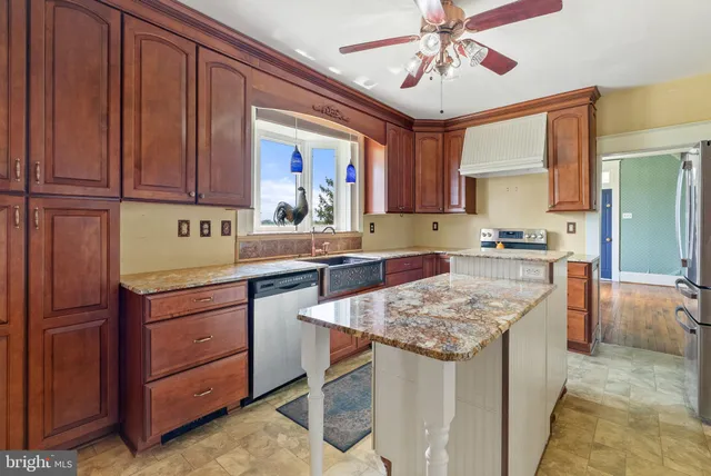 a kitchen with kitchen island granite countertop wooden cabinets a sink and dishwasher
