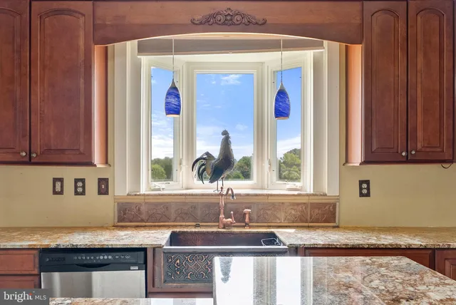 a kitchen with stainless steel appliances granite countertop a sink and a window