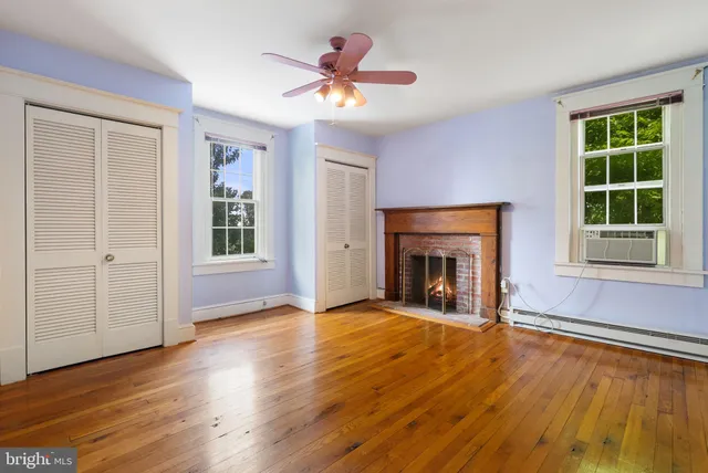 wooden floor fireplace and windows in an empty room