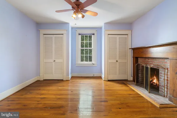 a view of an empty room with window and fire place