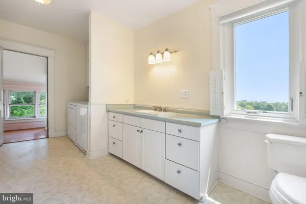 a spacious bathroom with a granite countertop sink mirror and a toilet