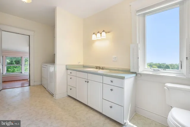 a spacious bathroom with a granite countertop sink mirror and a toilet